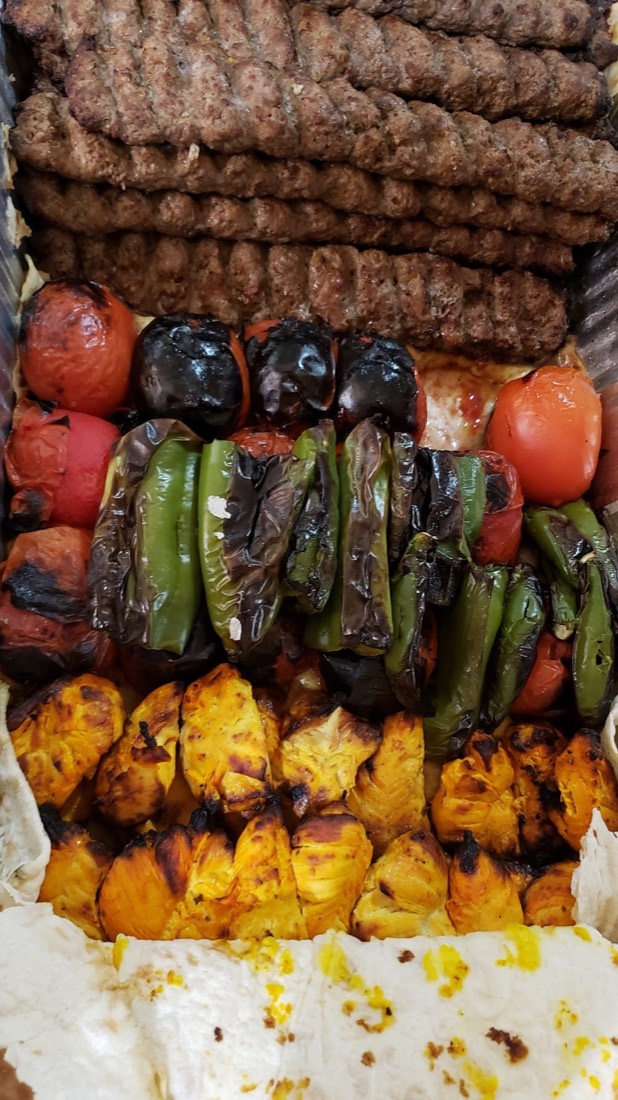 Catering tray of luleh kabob, grilled tomatoes, peppers and chicken kabob